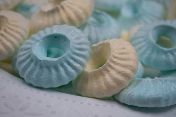 Piped sultane meringues on white plate