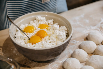 Bowl of cottage cheese with eggs on a wooden table.