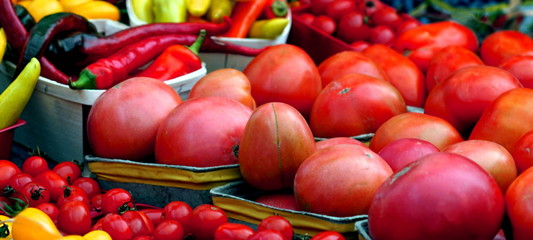 Close up full frame of vegetables in a market tomatoes peppers 