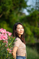 Beautiful Asian woman alone in the park with pink flowers
