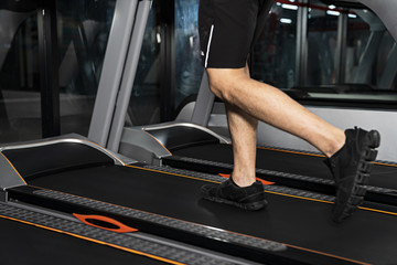 Fototapeta na wymiar Close up of male legs running on treadmill in gym, Sport fitness training, Lifestyle people concept