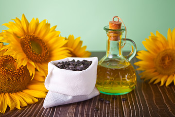Sunflower oil in a bottle and sunflower seeds on the wooden table.