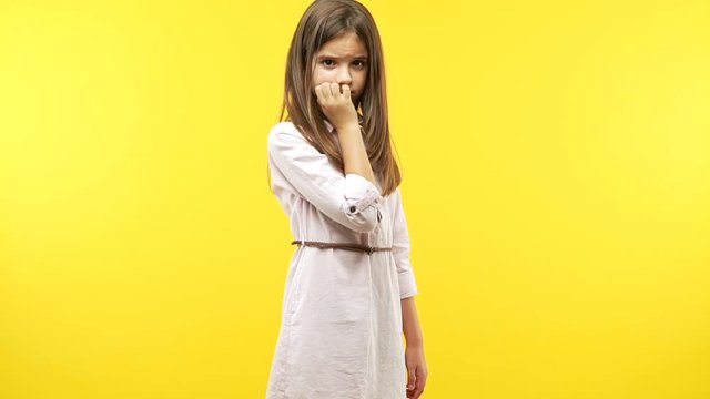 Funny little child girl biting nails, nervous and very anxious 