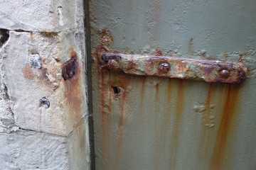 Extrem rostige metallene Türverriegelung. Lange braune Korrosionsstreifen durch zu viel Regen und...