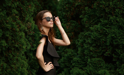 Naklejka premium Fashionable beautiful woman is wearing sunglasses in the park