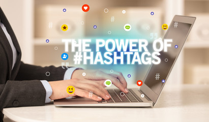 Freelance woman using laptop with THE POWER OF #HASHTAGS inscription, Social media concept