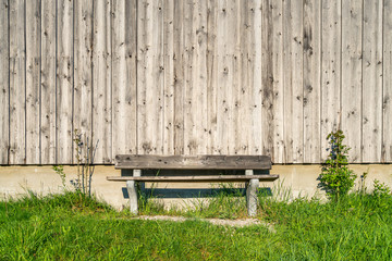 Naklejka premium Holzbank zum Ausruhen vor einer Holzwand