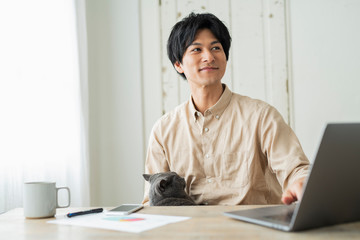 One man working remotely and a cat.