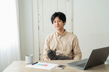One man working remotely and a cat.