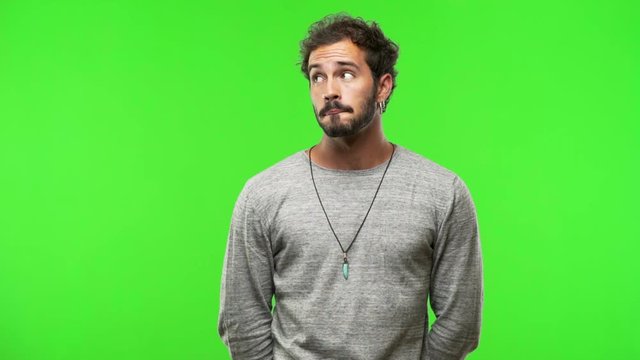 young man on chroma green screen thinking about an idea