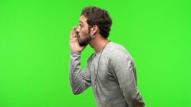 young man on chroma green screen whispering gossip undertone