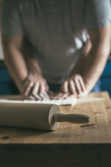 Preparing pizza dough. Young couple makes pizza for dinner. Romantic dinner. Cooking pizza at home. Rolling pin and flour on the table. Woman's and  man's hands together.