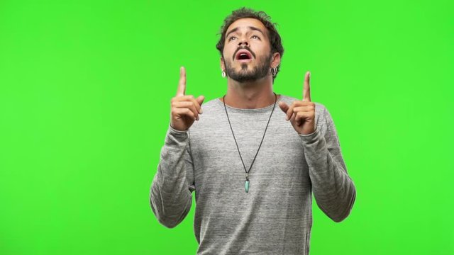 young man on chroma green screen pointing up
