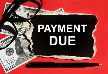 Payment due concept, written on black paper, white letters, on a red background.
