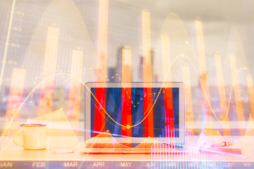 Stock market graph on background with desk and personal computer. Double exposure. Concept of financial analysis.