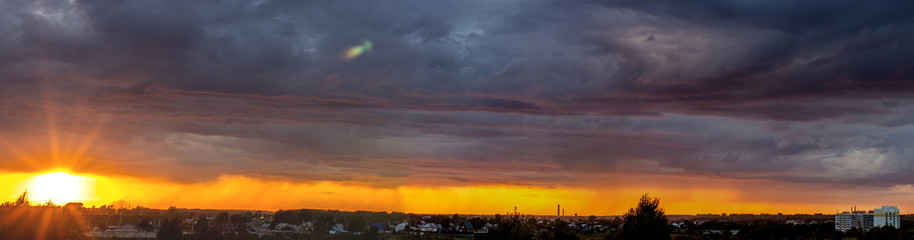 Very beautiful sunset in the city or village. Pink-orange sky with clouds.