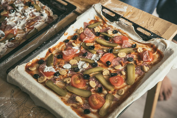 Preparing pizza at home. Homemade pizza. The lifestyle of modern young family. Pizza time. Unhealthy food.