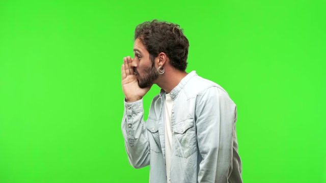 young man on chroma green screen whispering gossip undertone