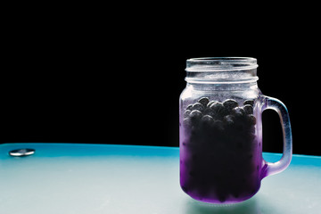 Beautiful purple jar shaped mug full of ripe juicy fresh berries