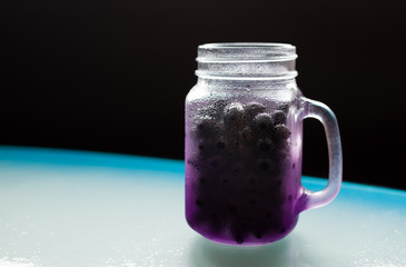 Beautiful misted purple jar shaped mug full of ripe juicy fresh berries