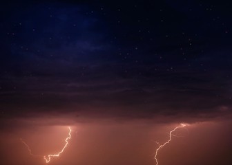 Lightning and storm clouds in the night sky over the sea