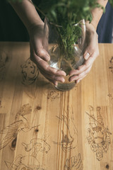 Wooden table with pictures. There is a vase of daisies on the table out of focus