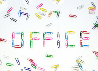 Obraz premium Made up of multi-colored paper clips the word office on a white background surrounded by other colored paper clips