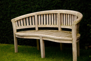 Closeup shot of a wooden bench in a park © Viktor Kiss/Wirestock