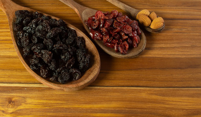 three spoons full of almonds, craberries and raisin