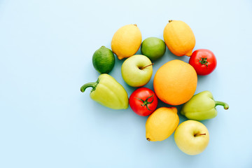 Various fresh vegetables and fruits on blue background. Shopping concept. Tomato, pepper, lemon, apple and lime. Top view