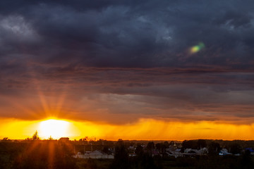 Very beautiful sunset in the city or village. Pink-orange sky with clouds.