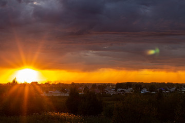 Very beautiful sunset in the city or village. Pink-orange sky with clouds.