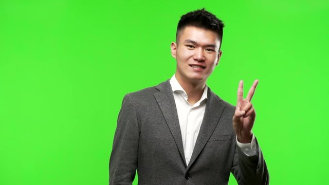 Young chinese business man doing a gesture of victory