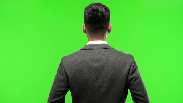 Young chinese business man from behind, looking back