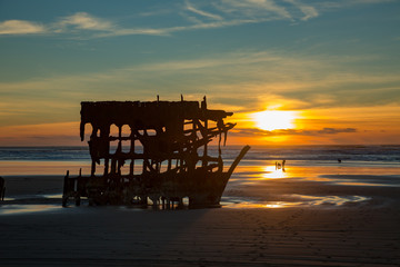 Fototapeta na wymiar The wreck of the Peter Iredale at sunset on the Oregon coast near Warrenton.