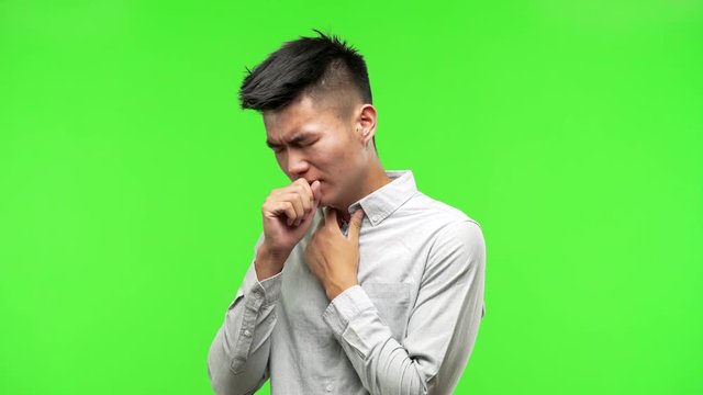 Young handsome chinese man coughing