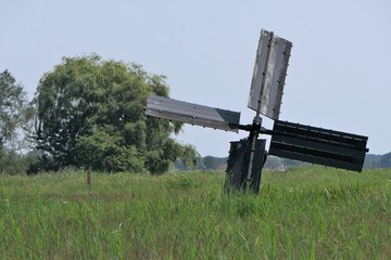 Historic windmill, Paaltjasker, used for drainage purposes in Friesland, province of the Netherlands, standing in a field