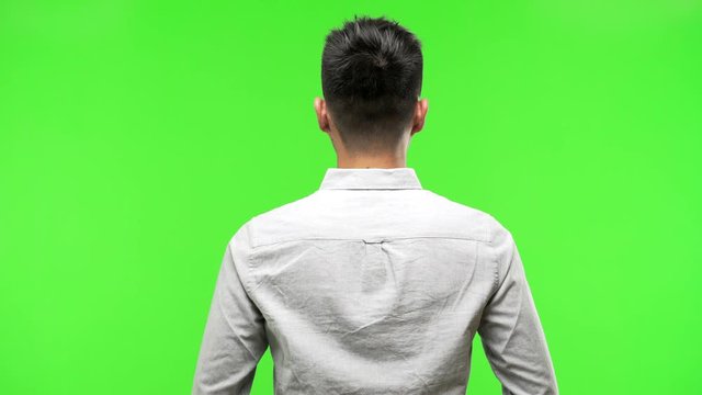Young handsome chinese man from behind, looking back