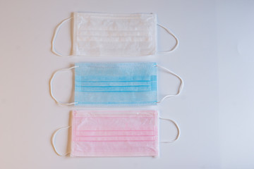 Masks of various colors were arranged on white backgound. Healthcare and medical concept.