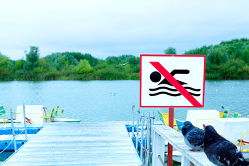 no swimming sign on the beach. lake embankment