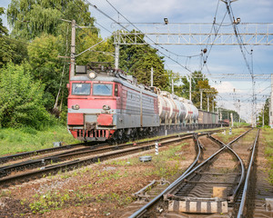 Naklejka premium Freight train approaches to the station at summer day.