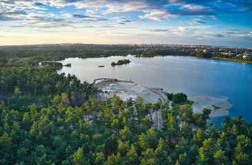 Obraz premium Lake near the forest and the city in the background