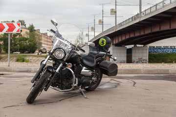 Black motorcycle on parking under the bridge