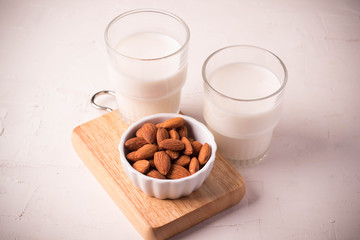 Close up. Almonds in a white ceramic cup and a milk glass.