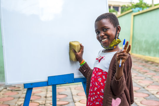 Closeup Shot Of A Black Male Child Erasing A Whiteboard - Education Concept