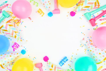 Birthday party frame on a white background. Top view with balloons, party hats, streamers and...