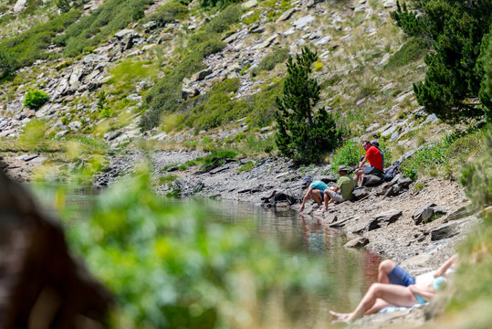 COMA PEDROSA, ANDORRA - Aug 07, 2020: Group of tourists resting at Lago de les Truites in Andorra Pyre