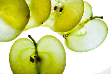 Slices of apple at the backlight isolated on a white background, macro photo