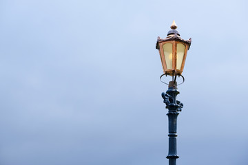 Fototapeta na wymiar Back and copper victorian lamp post and dark sky