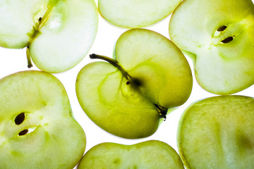 Slices of apple at the backlight isolated on a white background, macro photo